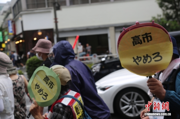 当地时间8月15日，日本民众在东京淡路公园附近举行抗议游行，反对政客向供奉有二战甲级战犯的靖国神社供奉祭祀费或参拜。图为手举“高市下台”标语牌的抗议者。<a target='_blank' href='/'>中新社</a>记者 朱晨曦 摄
