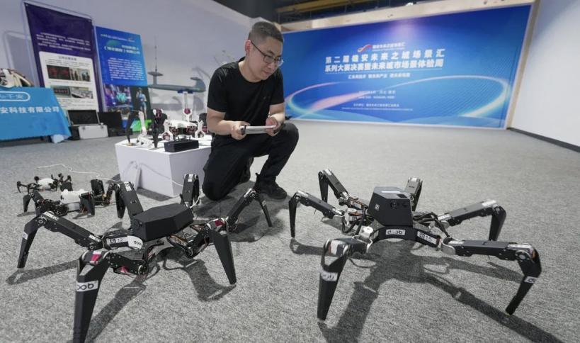 工作人员正在展示行动灵活的六足机器人。李畅摄